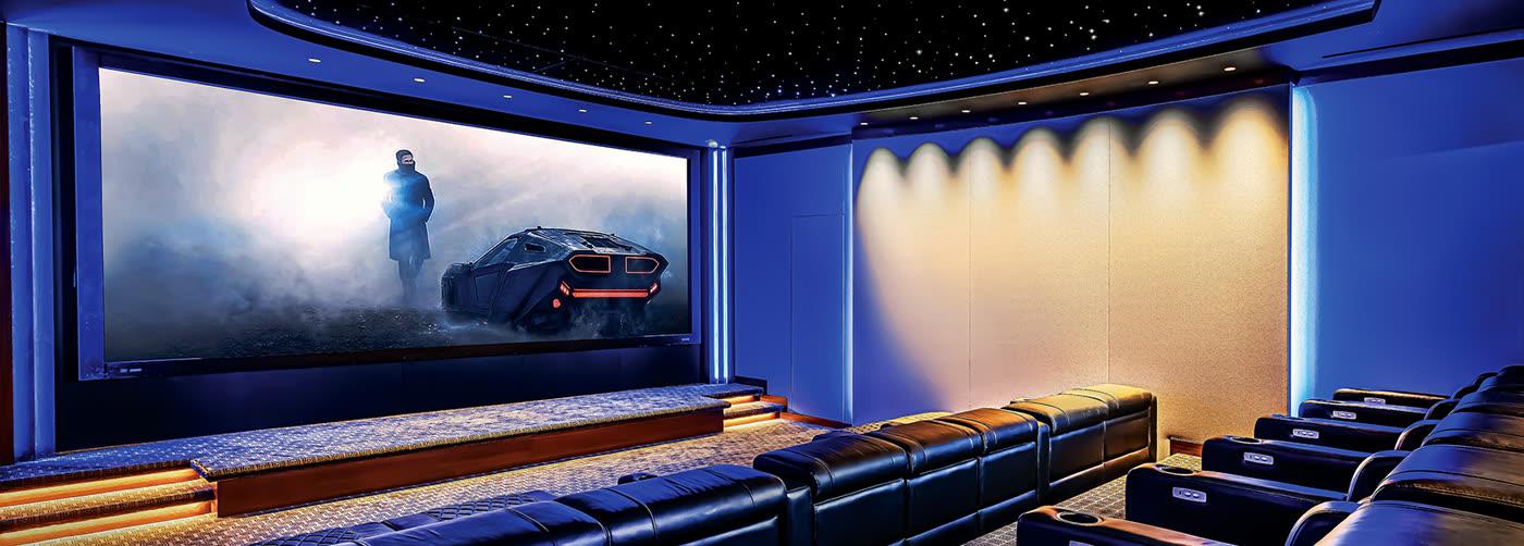 AcousticSmart custom luxury home theater with curved screen and tiered leather seating