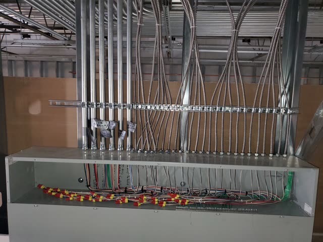 Elite Electrical Contracting wiring enclosure with multiple conduit entries and organized conductors