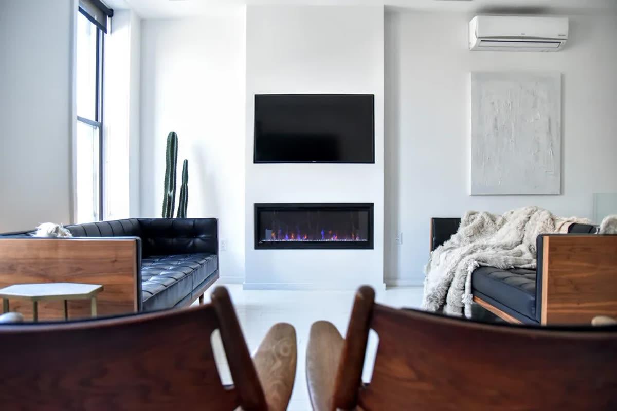 Homework Renovation New York living room with television, linear fireplace, built-in wall, and daylight