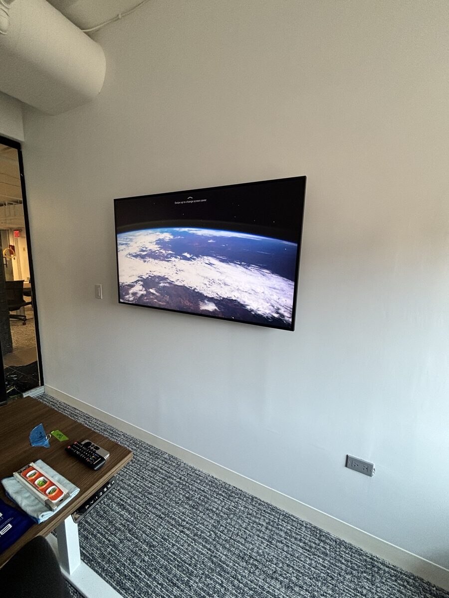 Private office with a wall-mounted 55-inch Samsung display used for AirPlay from Apple devices