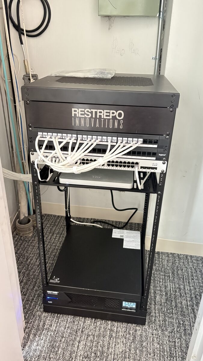 Restrepo Innovations 21U mobile rack in the 9th floor AV closet with labeled patch panels and managed UPS