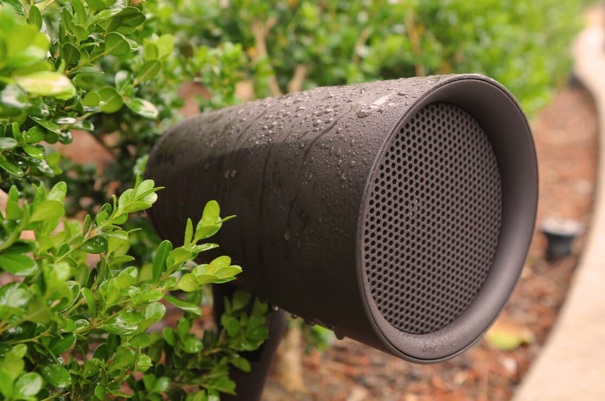 Origin Acoustics outdoor audio speaker in a rain-soaked landscape for a residential outdoor audio system