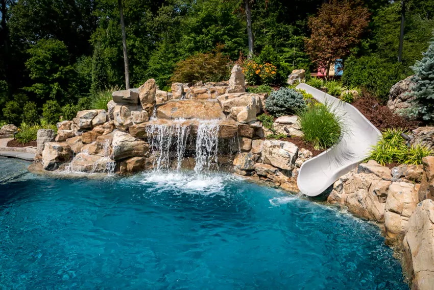 Resort-style natural rock waterfall pool with slide, designed and built by Terracare
