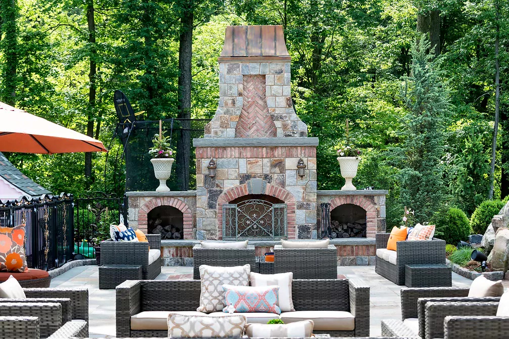 Custom stone outdoor fireplace and entertaining terrace by Terracare Landscaping